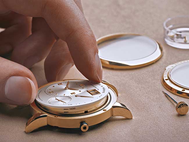 Uhrmacher kontrolliert und montiert alle Einzelteile einer Uhr bevor diese in die Endkontrolle geht